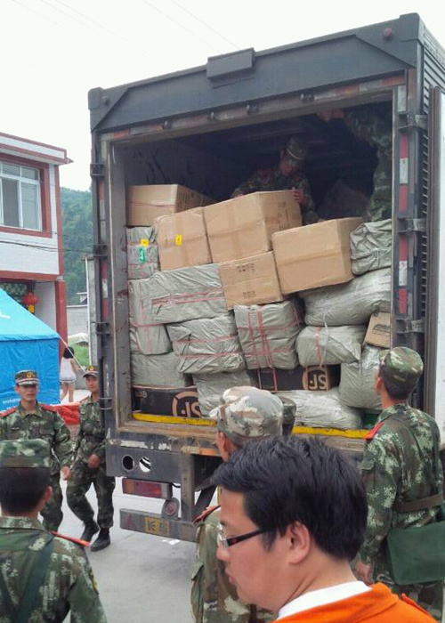 森林、消防武警戰(zhàn)士幫忙從大貨車上卸下救災(zāi)物資.jpg
