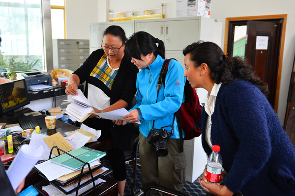 a國內部副部長莫莎在幸福工程達孜縣辦公室查看檔案和票據