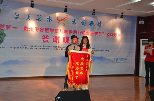 受助患兒代表向中國人口福利基金會贈送錦旗