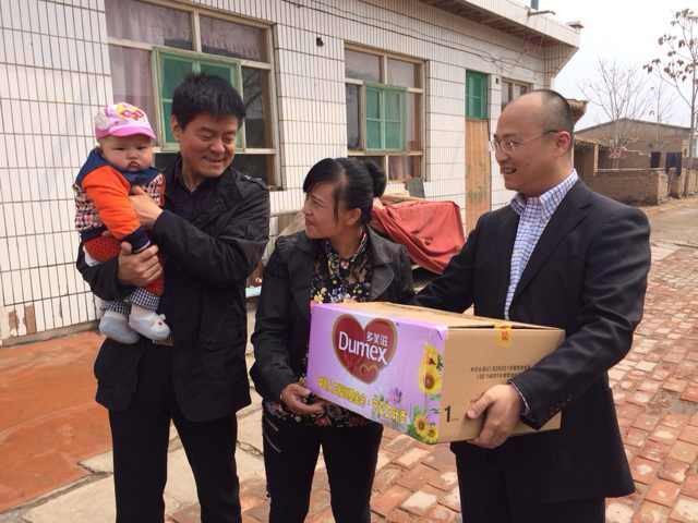 多美滋西區營養副總監陳磊向受助家庭發放奶粉