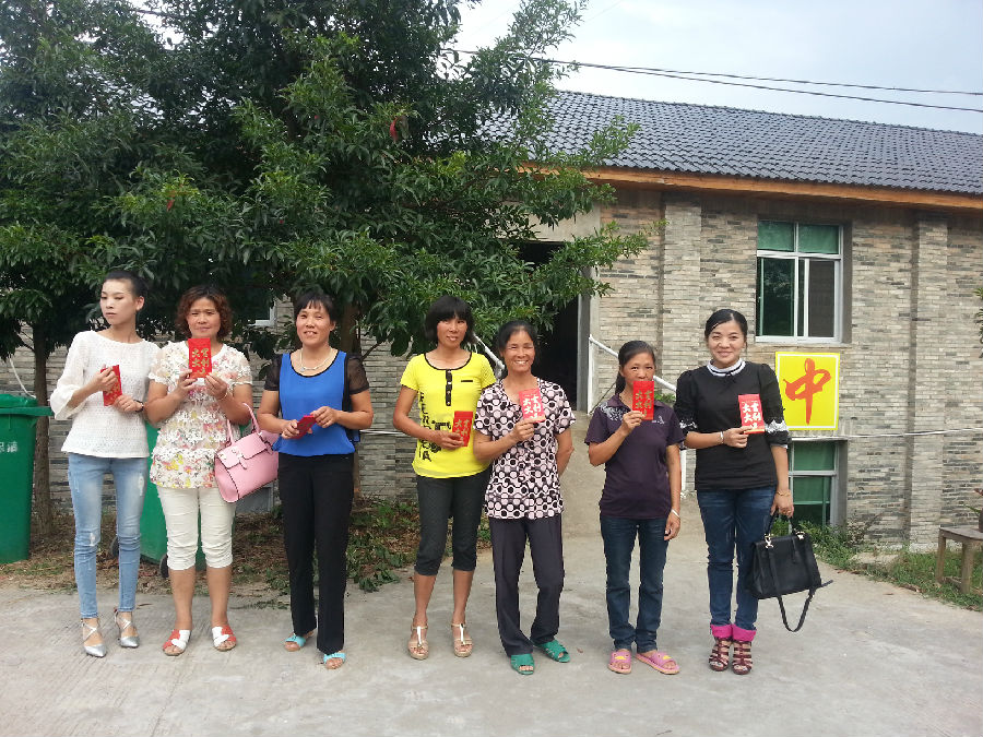 获得分红的幸福母亲高兴地手拿分红合影留念。