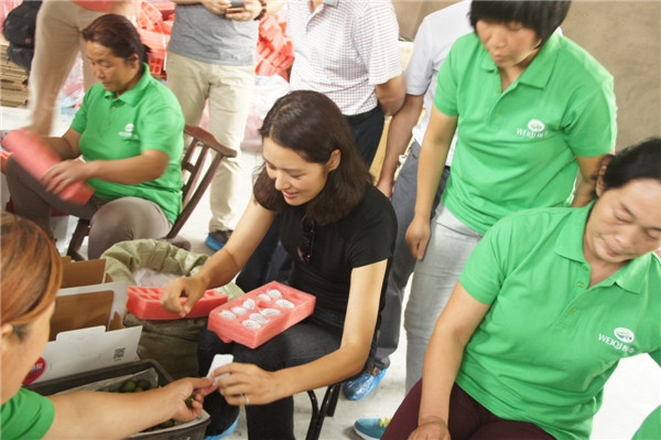 5 馬艷麗女士在電商車間與貧困母親共同包裝鮮果.jpg