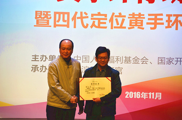 1479348999117528.jpg 基金會秘書長張暉向北京中醫(yī)研究院西苑醫(yī)院老年科主任劉征堂頒發(fā)“黃手環(huán)行動”愛心單位獎杯和“黃手環(huán)行動”榮譽證書。_副本.jpg