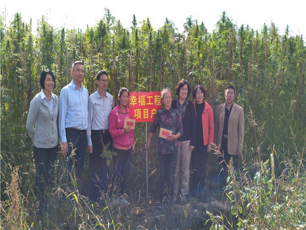 郝林娜理事長一行與受助母親高云翠、徐紅在自家漢麻種植地前合影留念.jpg