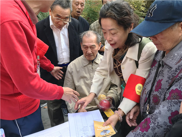 1509327575102888.jpg 上海善家黃手環行動志愿服務隊洪凌副隊長正在為老人申辦黃手環(1).jpg