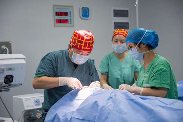 來自云南省第二人民醫院的外科醫生駱琦正為患兒實施修復手術.png