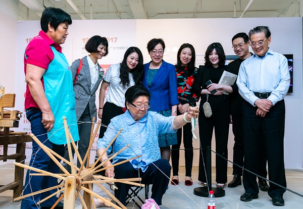 1527388244546073.jpg 顧秀蓮主任觀展現場體驗紡線織布.JPG